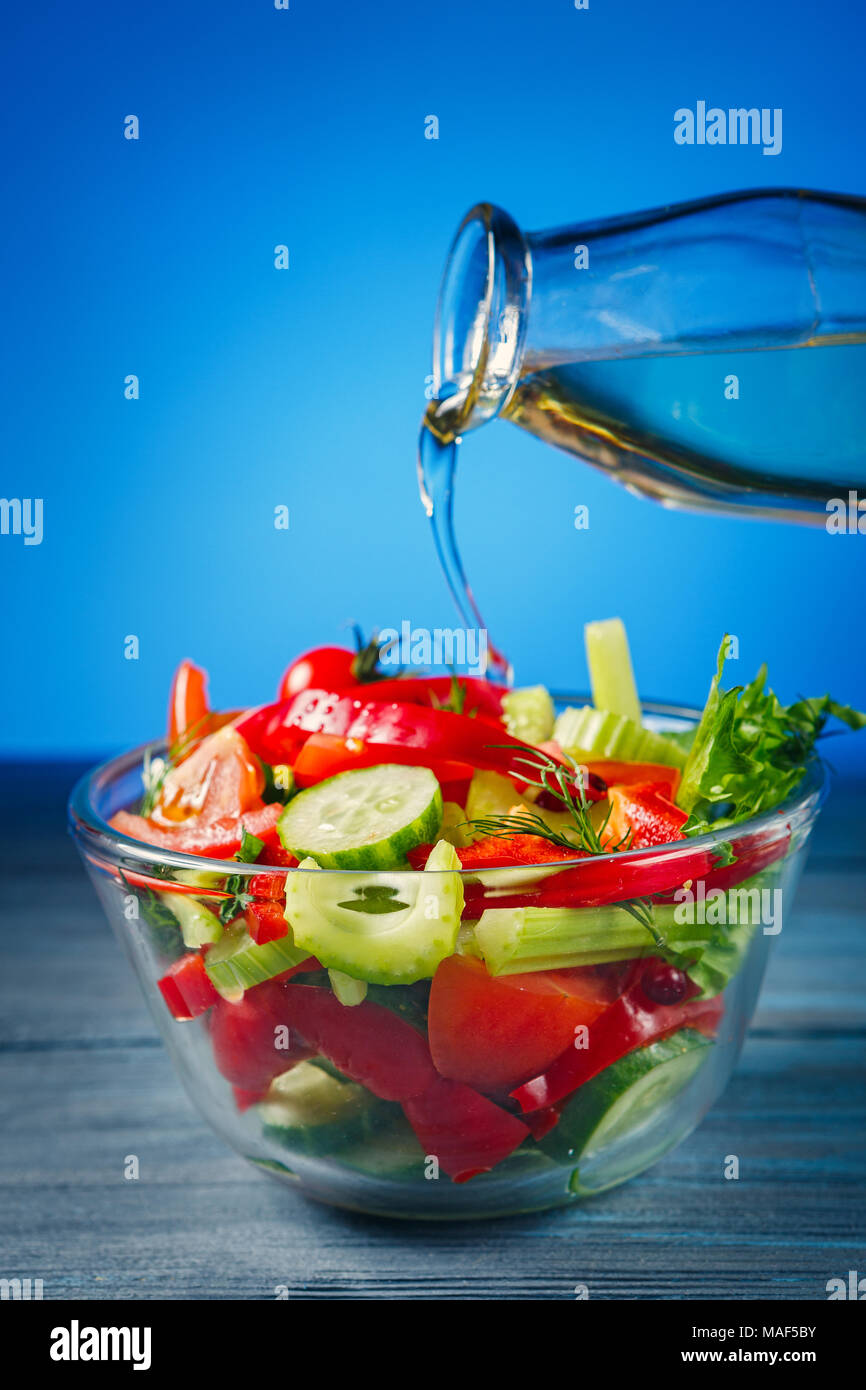 Bol de salade avec des légumes frais et d'huile d'olive sur fond de bois Banque D'Images