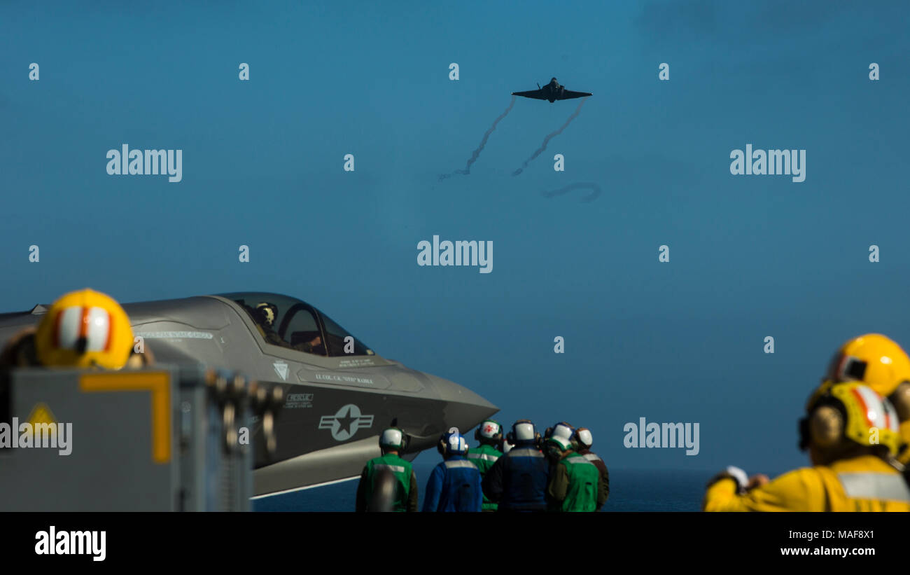 Les Marines et les marins à bord de la classe Wasp-navire amphibie USS Essex (DG 2) regarder un F-35C de l'opérateur, à la variante, voler sur le navire, le 28 mars 2018. Le groupe amphibie d'Essex et 13e Marine Expeditionary Unit entièrement intégré pour la première fois avant leur déploiement d'été. L'Escadron amphibie, MEU intégration formation constitue un préalable essentiel qui permet à l'exercice de déploiement Navy-Marine Corps à l'équipe de planifier et d'exécuter rapidement des opérations complexes à partir de l'expédition navale. (U.S. Marine Corps photo par le Cpl. A. J. Van Fredenberg) Banque D'Images