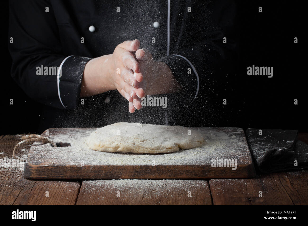 Femme chef part applaudir d'éclaboussure de la farine blanche sur fond noir  Photo Stock - Alamy