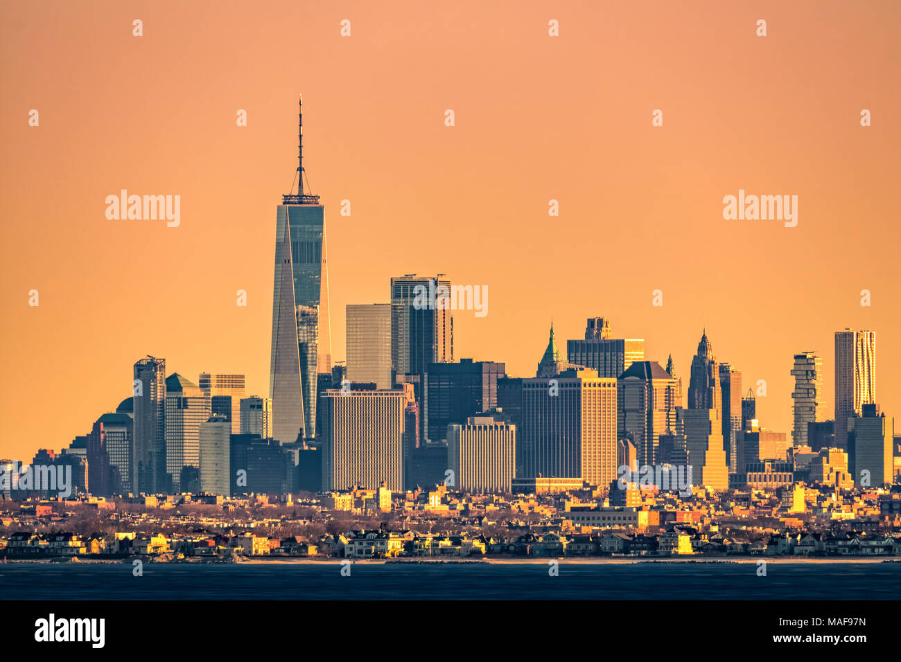 Les tours de New York skyline avec Brooklyn borough de faible hauteur à l'avant-plan, comme vu au lever du soleil, de Sandy Hook (New Jersey). Banque D'Images