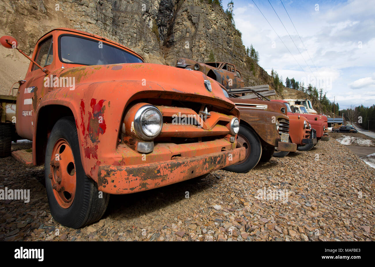 Un vieux, rouge 1955 camion Ford F-500 parmi une rangée de vieux camions, dans une carrière de pierres, à l'Est de l'Idaho Clark Fork. Banque D'Images