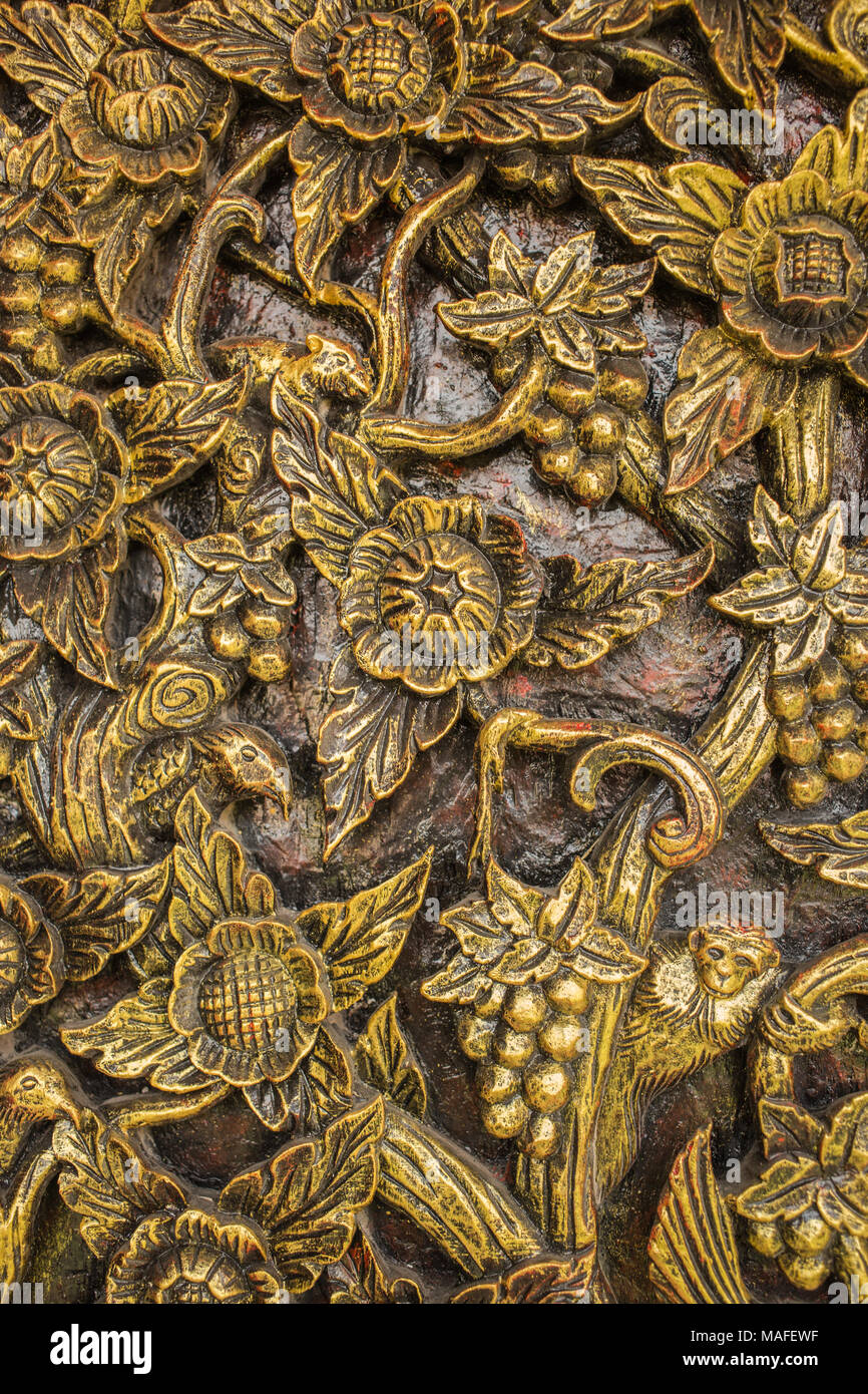 Fleur de motif sculpté sur fond de bois fait main en Asie. Banque D'Images