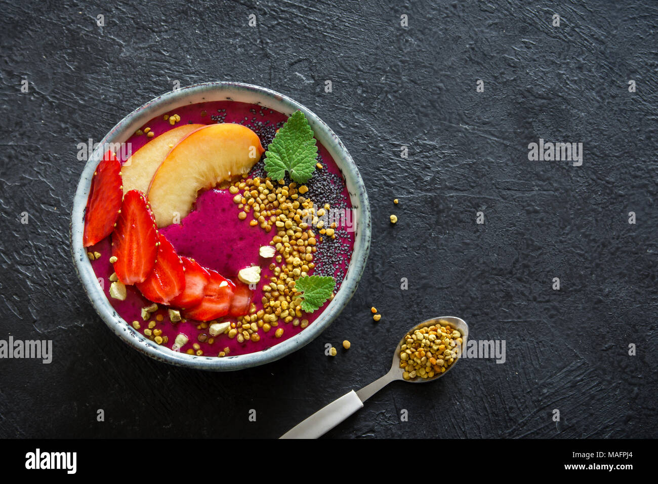 Smoothie Acai bowl avec chia Graines, fruits, petits fruits (fraises) et du pollen d'abeille pour un régime végétarien végétalien matières petit-déjeuner. Smoothie Déjeuner Banque D'Images