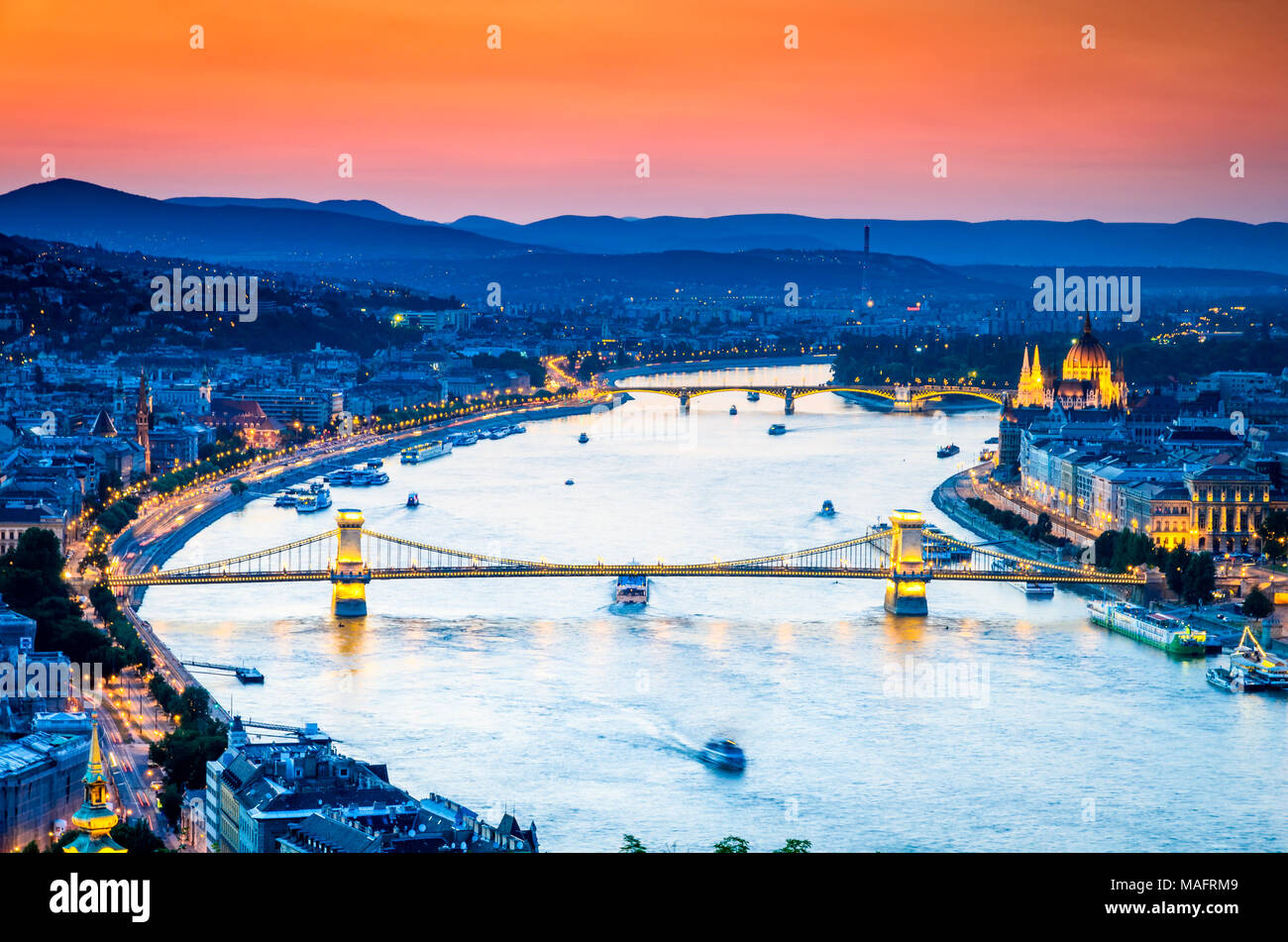 Budapest, Hongrie. Plus de coucher de soleil spectaculaire pont des chaînes Széchenyi et le Parlement, le Danube. Banque D'Images