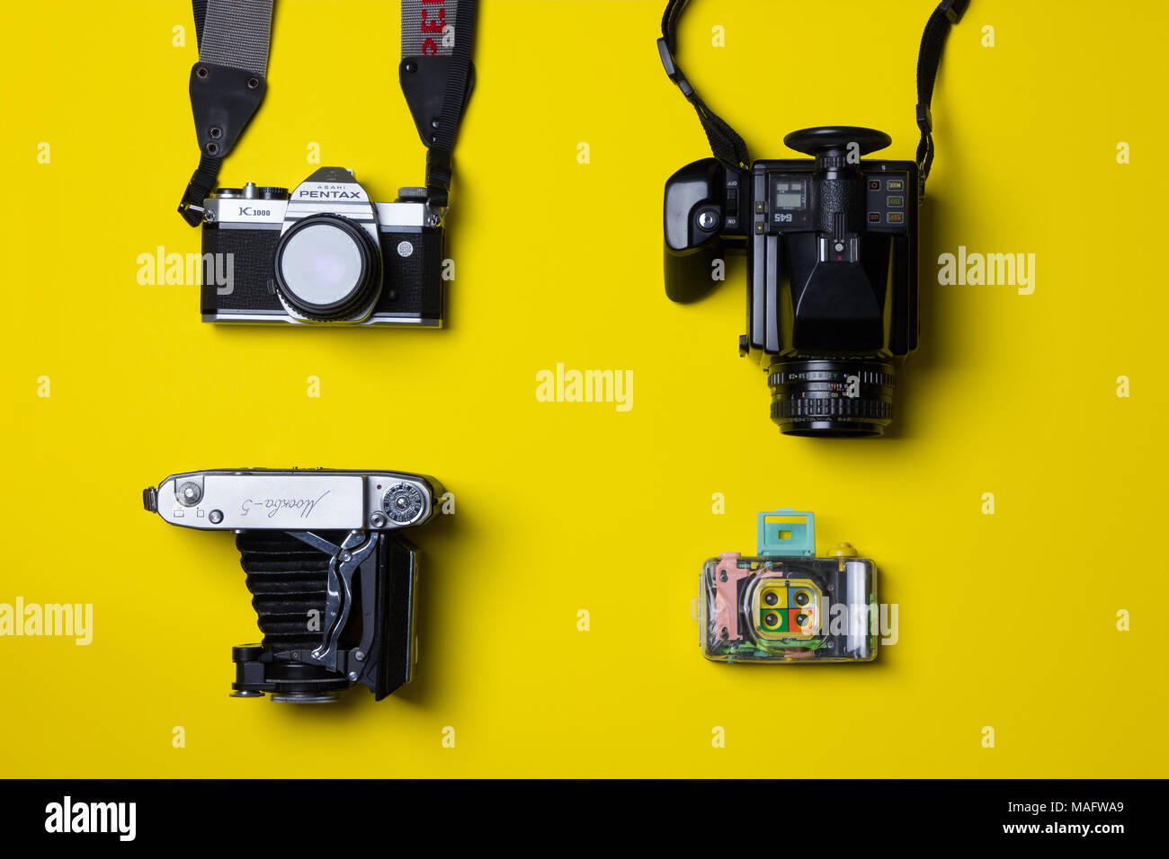 Un superbe portrait de caméras film pris d'en haut contre un arrière-plan jaune vif Banque D'Images Un superbe portrait de caméras film pris d'en haut contre un arrière-plan jaune vif Banque D'Images