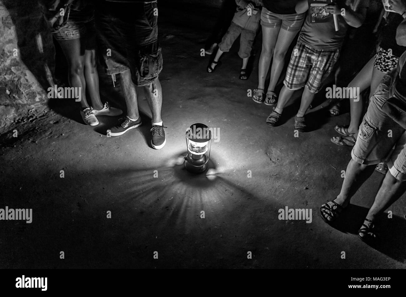 Un groupe de personnes debout dans une caverne qui est éclairé par une lampe sur le terrain Banque D'Images