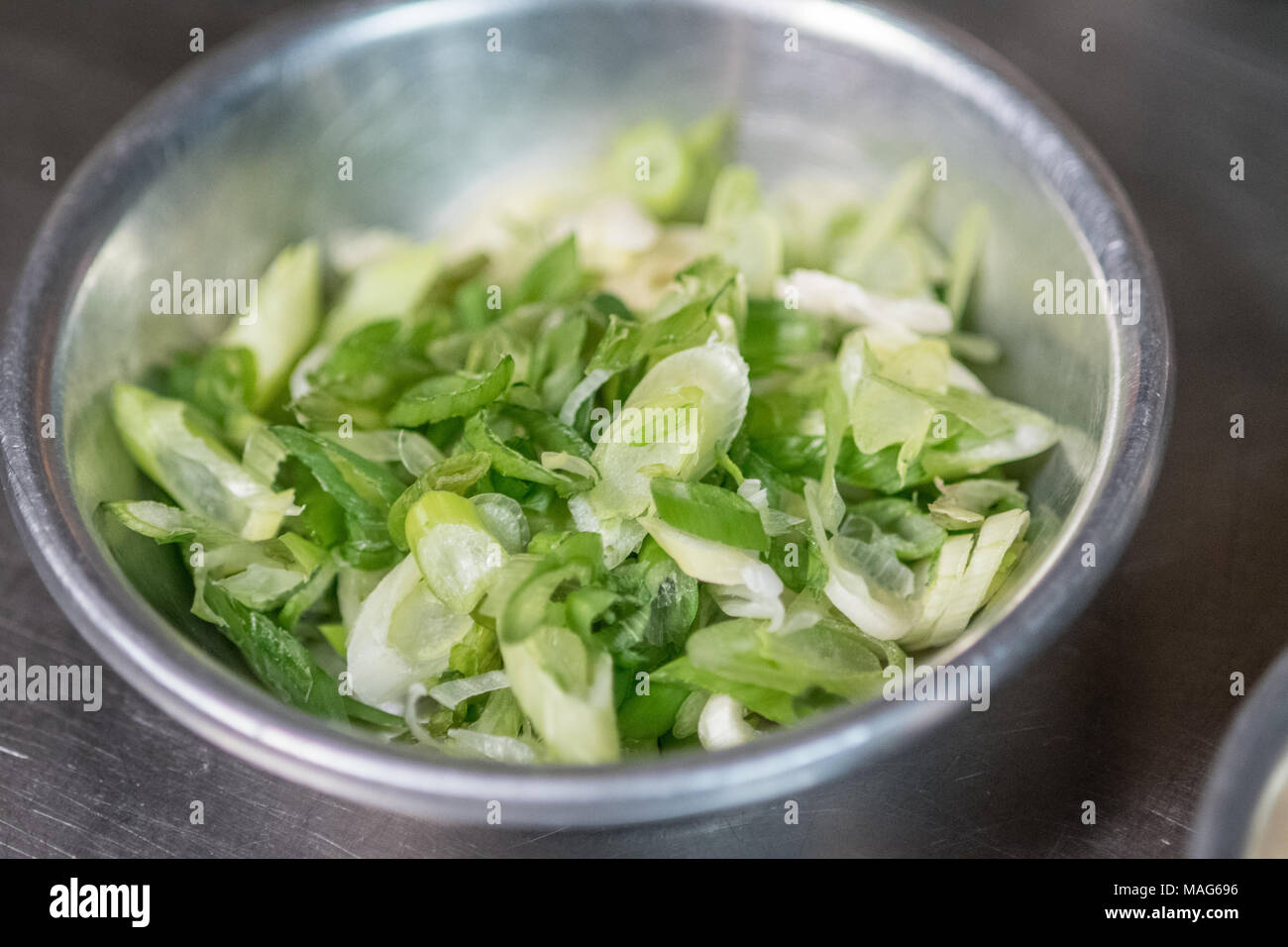 Oignons verts tranchés fraîchement prêt dans un bol pour la préparation des repas Banque D'Images