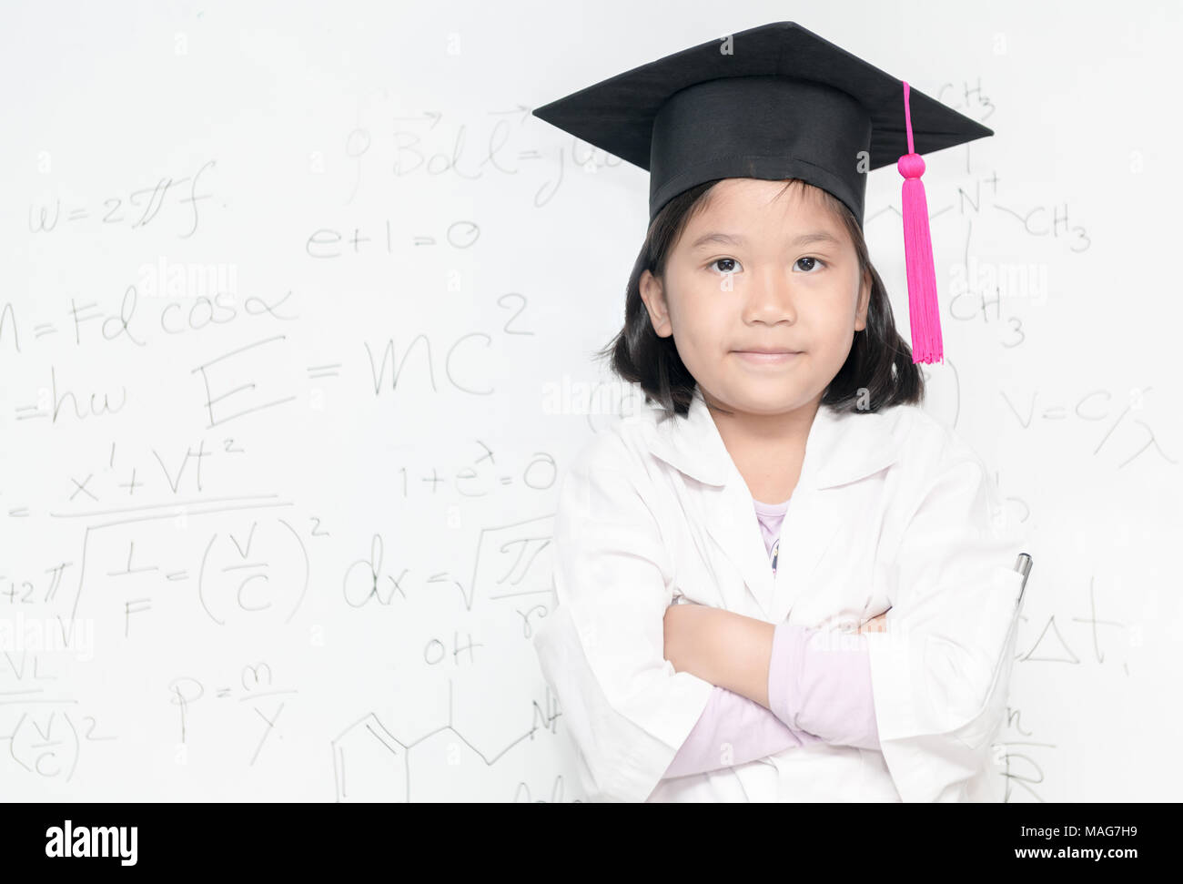 Cute asian girl scientifique porter graduation hat sourire sur inscription blanche avec l'équation scientifique, de la science et de l'éducation préscolaire concept Banque D'Images