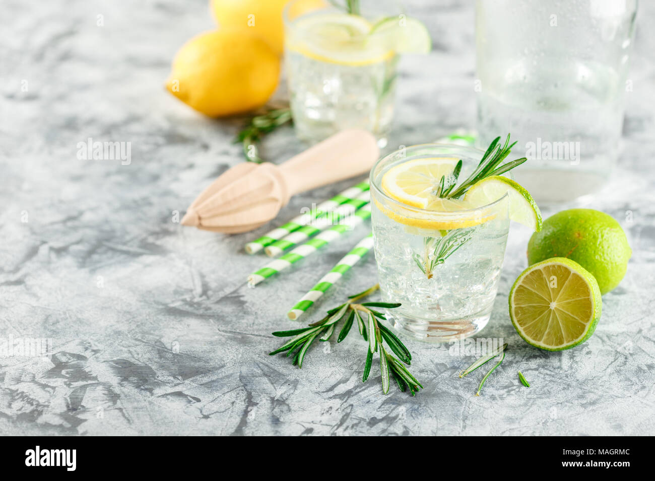 Boisson alcoolisée avec citron et rosemain, dans les verres sur une table lumineuse Banque D'Images