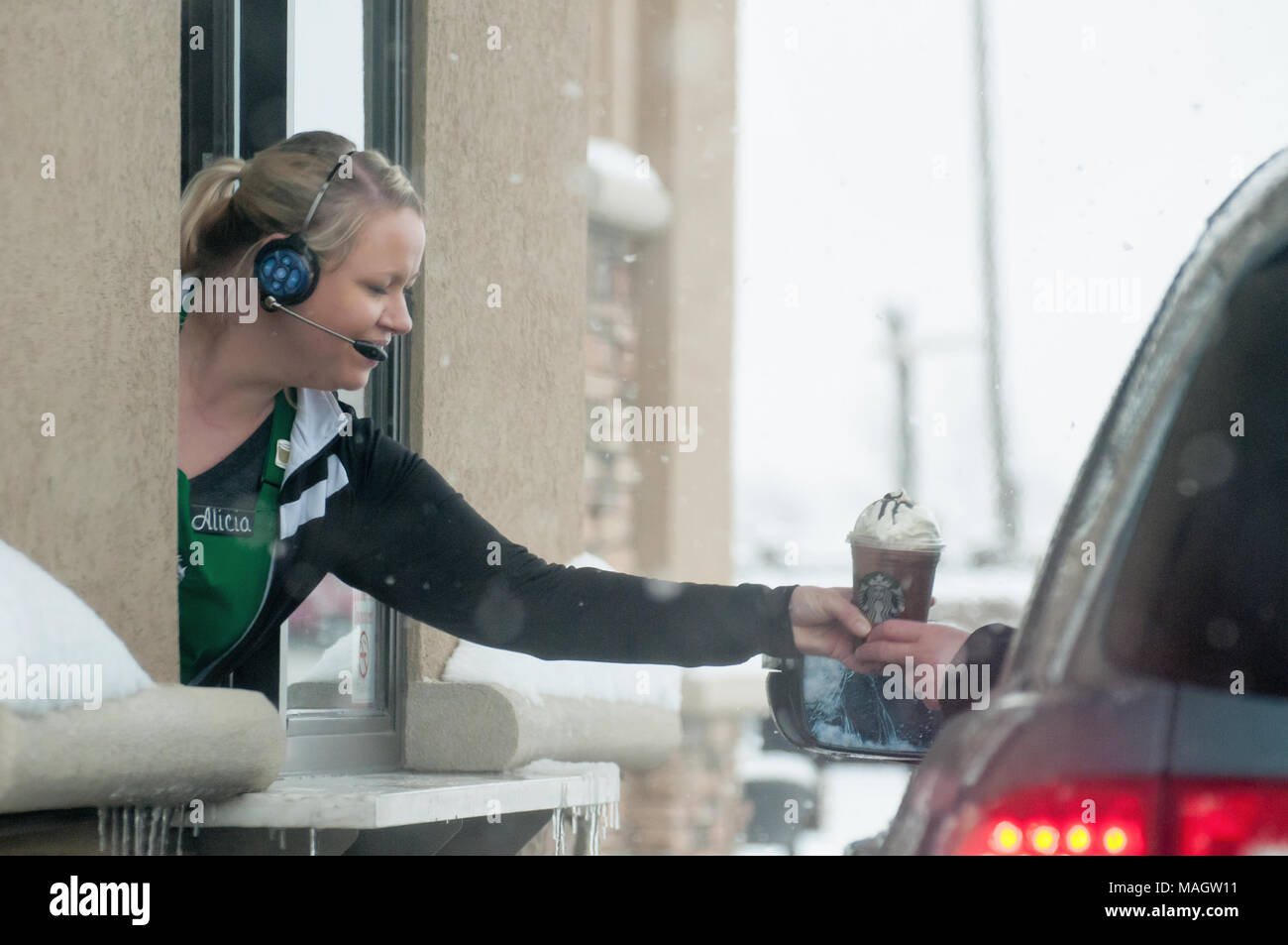 Un accompagnateur distribuer un café au Starbucks dans la neige. Banque D'Images