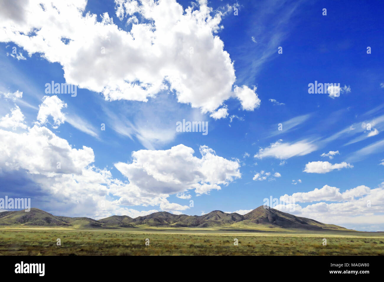 Des pics de montagne avec un superbe ciel bleu rempli de nuages cirrus filandreux. Banque D'Images