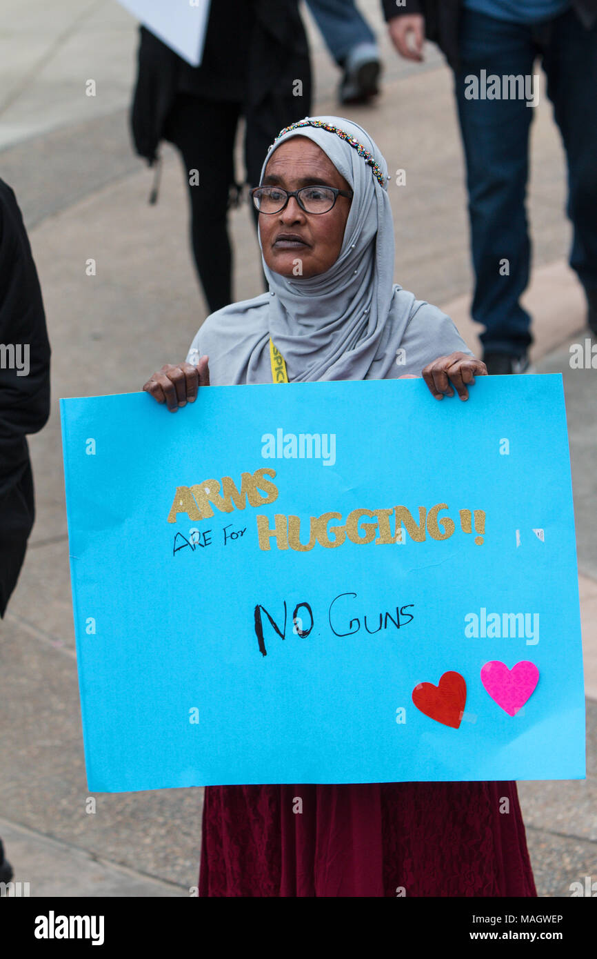 Atlanta, GA, USA - Le 24 mars 2018 : une femme musulmane se distingue et nous tend un panneau qui dit "les bras sont pour étreindre - pas d'armes,' à mars pour notre vie. Banque D'Images