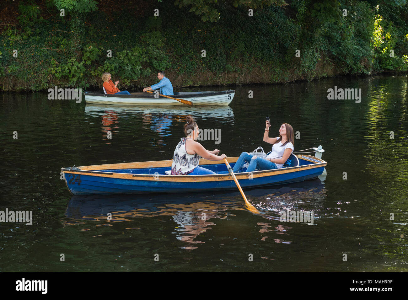 4 personnes bateau, de se détendre et s'amuser dans 2 barques (1 jeune femme en bateau prend Rivière Nidd selfies) - en été, Knaresborough, England, UK. Banque D'Images