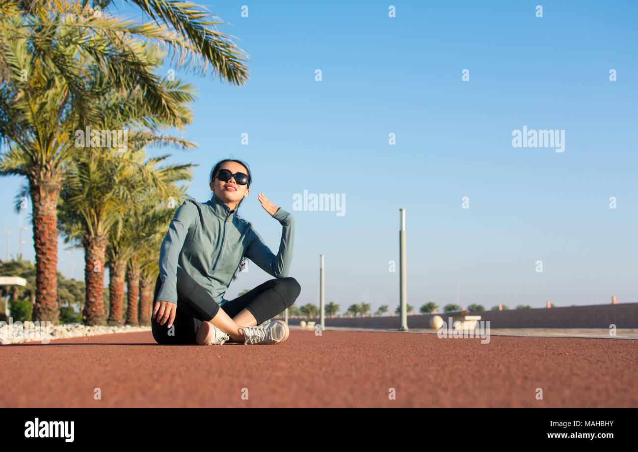 Fille assise sur une piste de course et de prendre une pause de workout Banque D'Images