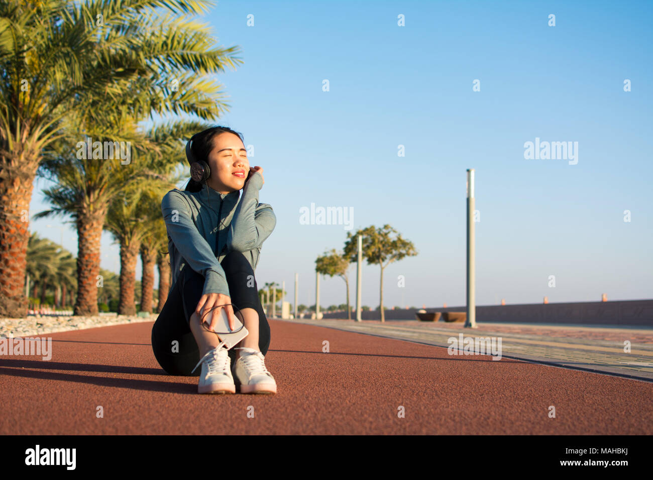 Fille assise sur une piste de course et de prendre une pause de workout Banque D'Images