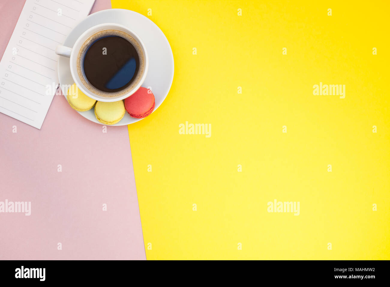 Télévision créative fixer photo de tasse à café et macarons et liste vide avec copie espace sur fond rose style minimal Banque D'Images