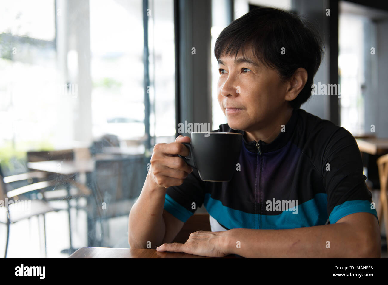Senior Asian woman with coffee en maillot Banque D'Images