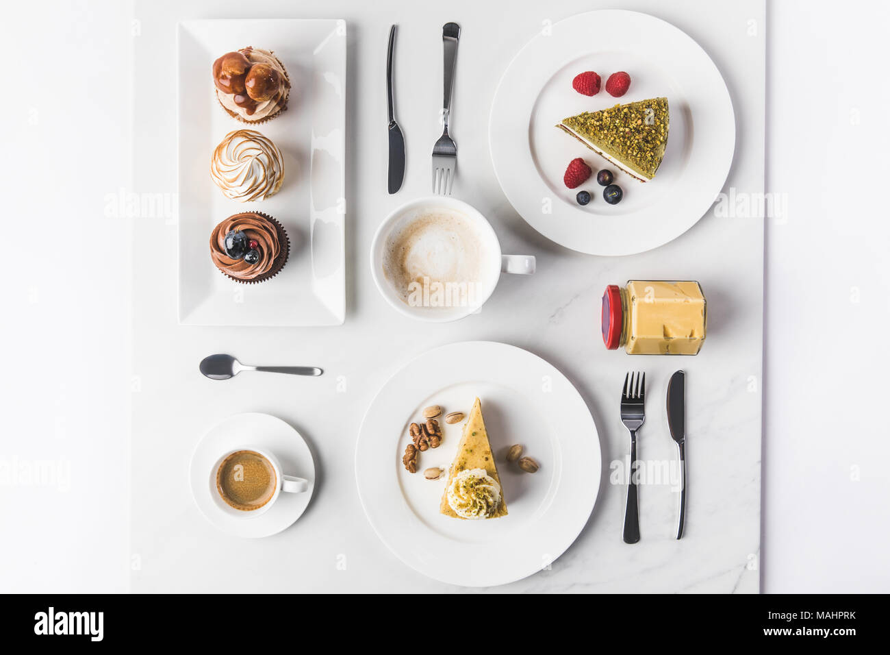 Vue du dessus de l'assemblage de pièces de différents gâteaux sur les assiettes, tasses de café et petits gâteaux isolated on white Banque D'Images