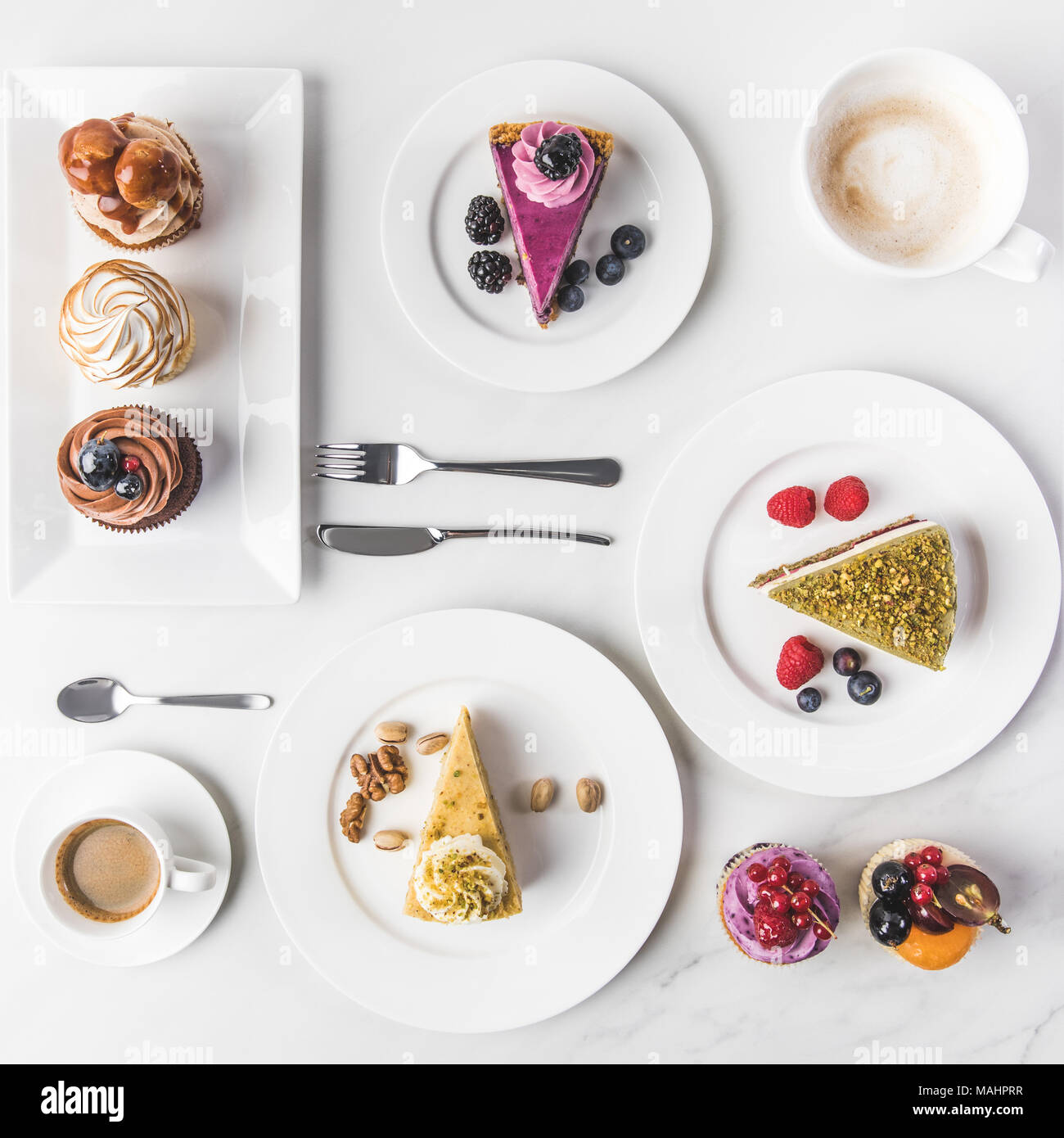 Vue du dessus de l'assemblage de pièces de différents gâteaux sur les assiettes, tasses de café et petits gâteaux isolated on white Banque D'Images