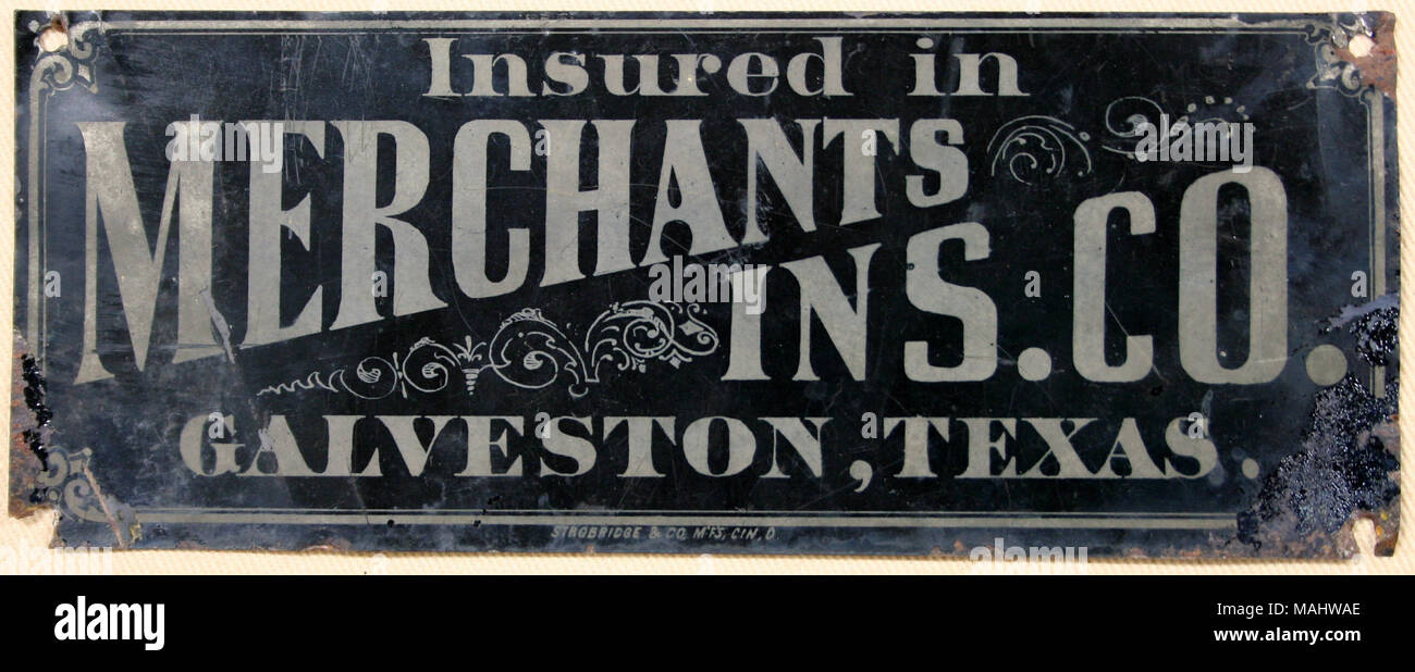 Étain peint feu mark pour les marchands Insurance Company de Galveston, Texas nom de l'entreprise montrant peint en or sur fond noir Titre : Fire mark pour les marchands Insurance Company de Galveston, Texas . Entre 1873 et 1875. Banque D'Images