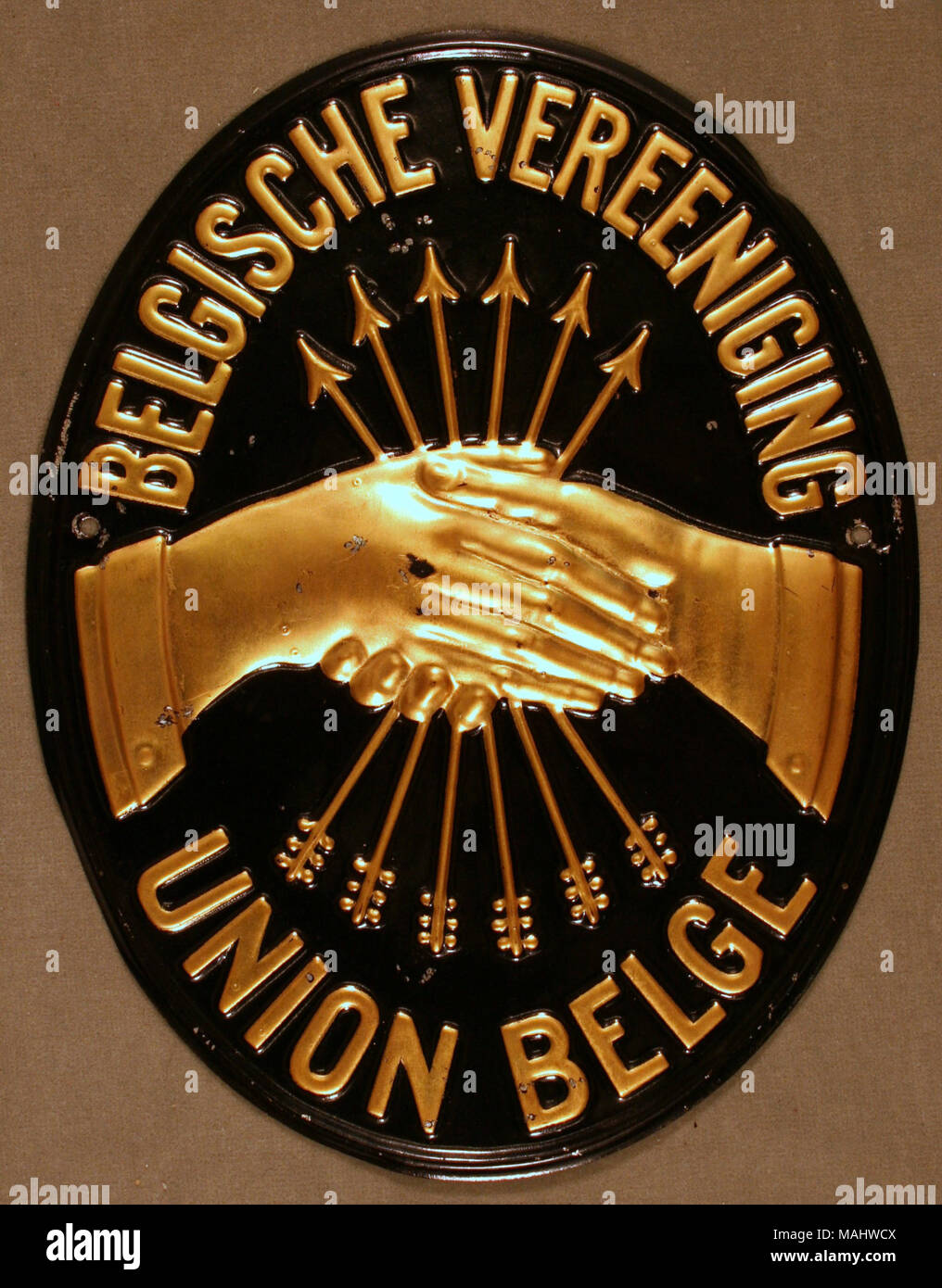 Feu d'étain pressé de passage pour l'Union Belge Societe Anonyme d'assurances contre l'incendie les explosions nucléaires et le chomage à Bruxelles, Belgique montre les mains jointes d'or et flèches avec lettrage doré sur fond noir Titre : Fire marque pour l'Union Belge Societe Anonyme d'assurances contre l'incendie les explosions nucléaires et le chomage à Bruxelles, Belgique . après 1824. Banque D'Images
