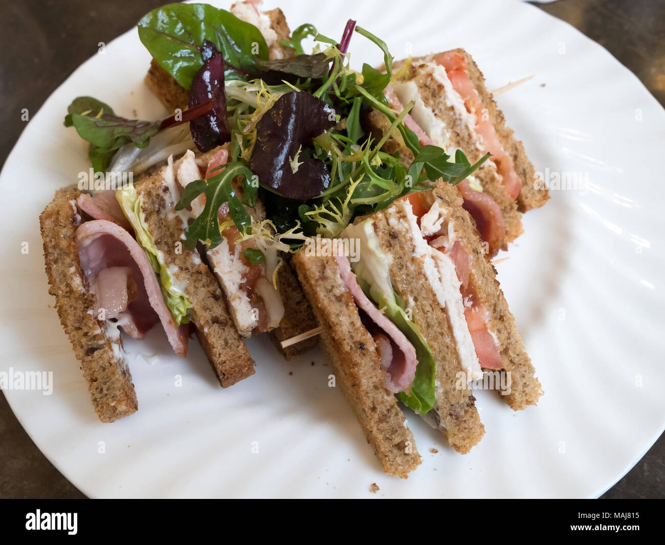 Un déjeuner café deux couche- Club Sandwich au pain brun avec du bacon laitue tomate et poulet avec salade mayo Banque D'Images Un déjeuner café deux couche- Club Sandwich au pain brun avec du bacon laitue tomate et poulet avec salade mayo Banque D'Images