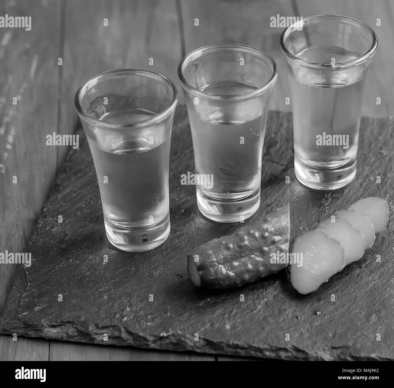 Petit verre de vin de vodka russe et concombre sel snack sur table en bois. copy space Banque D'Images