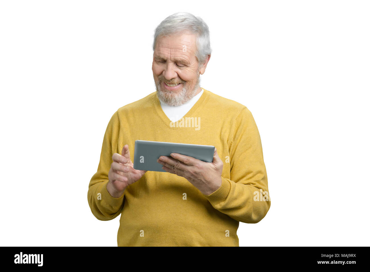 Portrait of cheerful grandpa tapping comprimé. Old man avec appareil moderne gadget. Fond isolé blanc. Banque D'Images