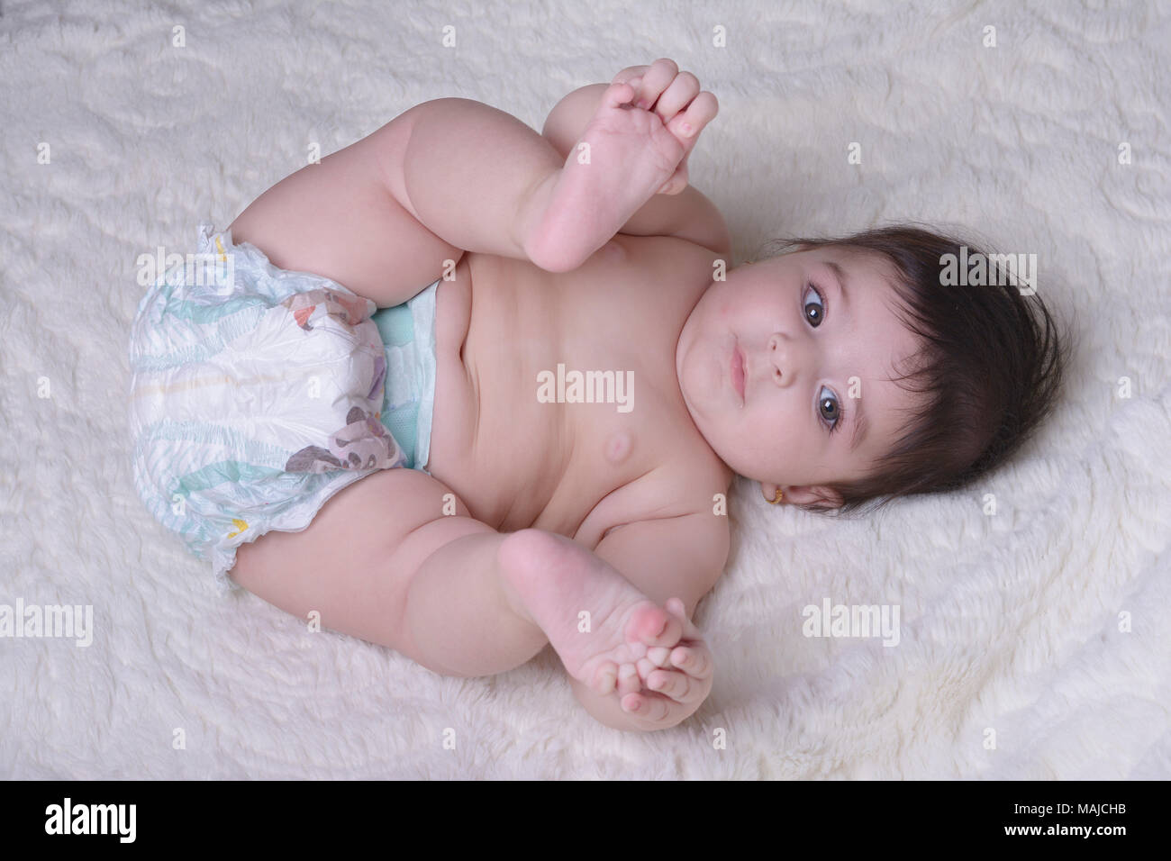 Petit Bebe Jouer Avec Ses Pieds Sur Une Couverture Blanche Literie Et Textile Pour Les Enfants Photo Stock Alamy