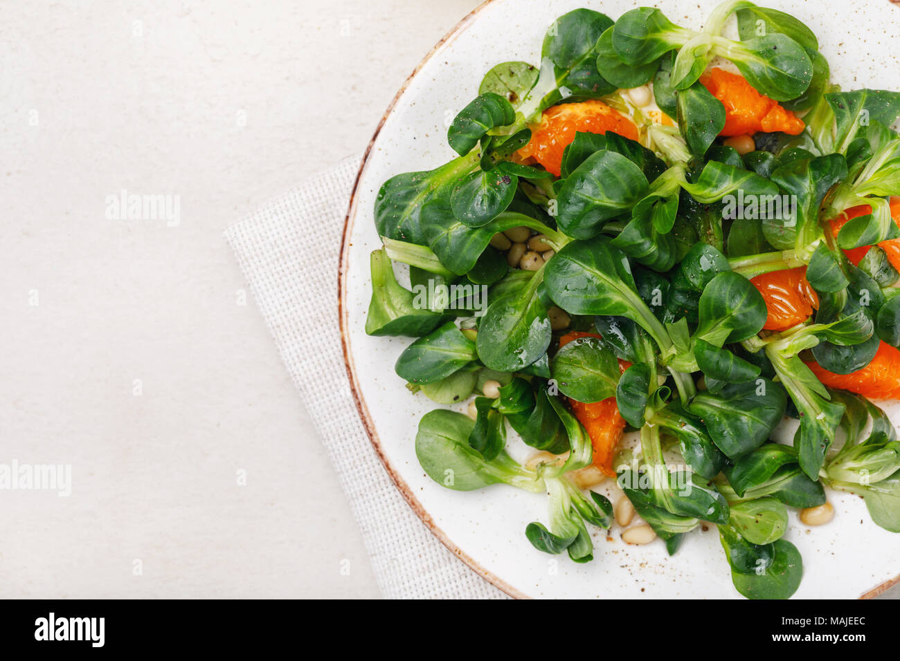 Korn délicate salade avec des noix de pin et de mandarine. Vue de dessus de la nourriture avec un espace réservé au texte Banque D'Images