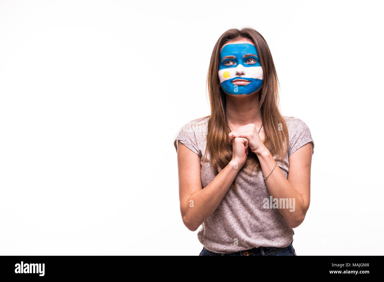 Le support de fan de l'équipe nationale argentine prie avec visage peint isolated on white Banque D'Images