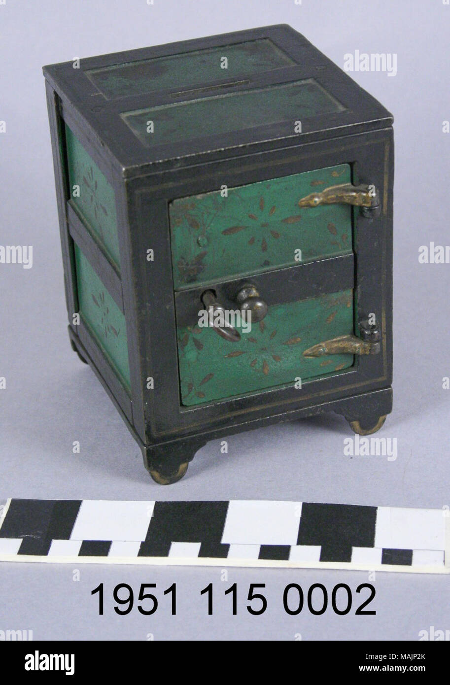 Banque de pièce de fonte dans la forme d'un coffre-fort. Peint en vert et noir avec quelques touches dorées. Fente de pièce sur le dessus. Titre : Vert et Noir Coin Bank dans la forme d'un coffre-fort . vers 1880. Banque D'Images
