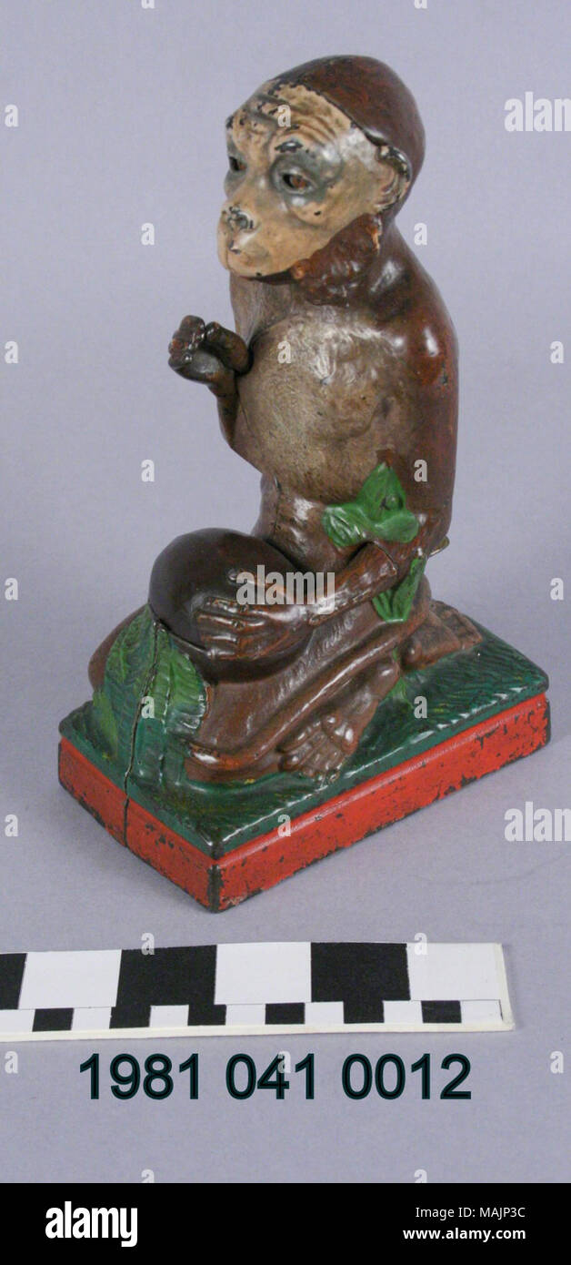 Banque mécanique en fonte en forme d'un singe et d'une noix de coco. Pour faire un dépôt, une pièce est placé dans la main droite. Poussant un levier provoque le singe à faire tomber la pièce dans la noix de coco. Fabriqué par la société Stevens J et E vers 1886. Titre : Monkey et coco pièce mécanique Banque . vers 1886. James H. Bigalow (Designer), J et E Stevens Company (bouilloire), Banque D'Images