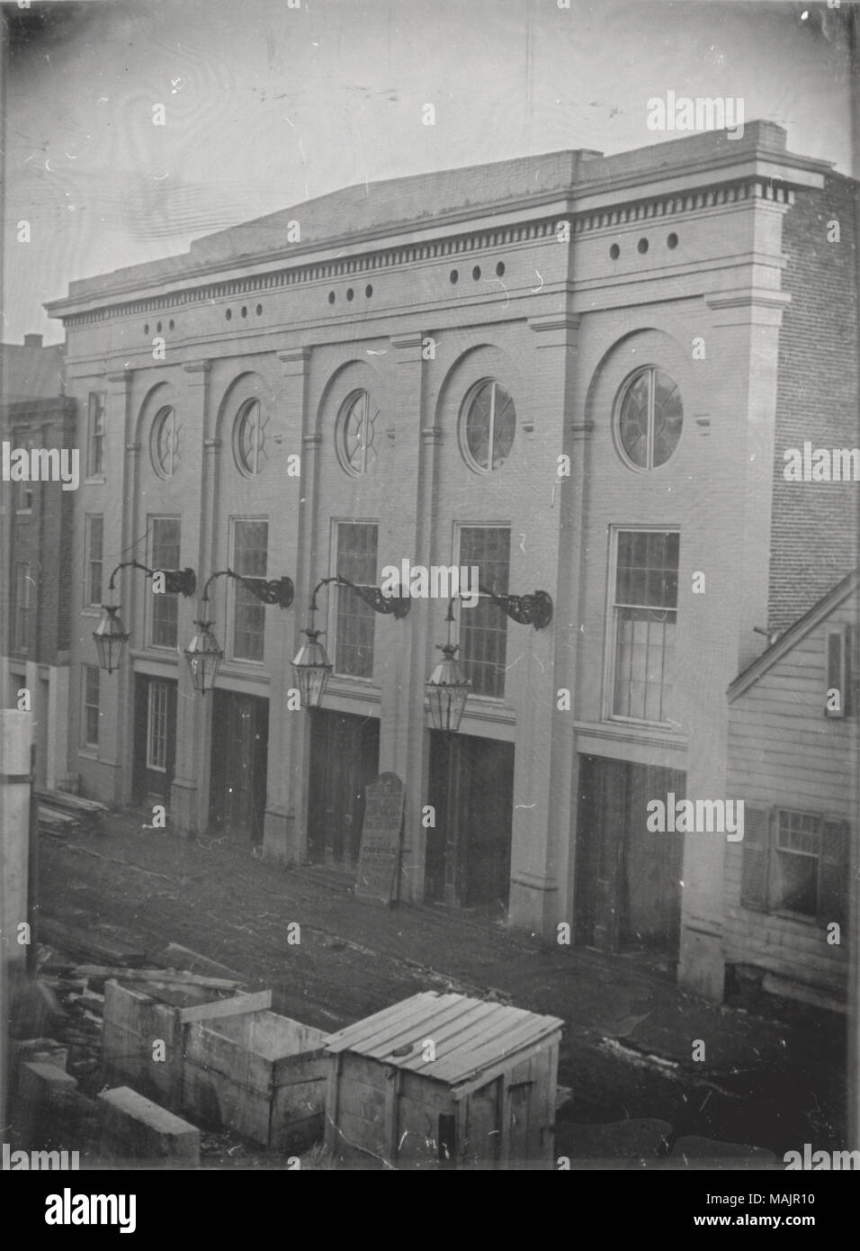 Vue de la People's Theatre. Quatre lampes accrocher au large des bâtiments et d'un signe se presse contre elle qui porte les informations telles que "People's Theatre', 'Miss Felix Bennett' et 'Willow Copse'. Une petite cabane en bois se distingue de l'autre côté de la rue, ainsi que de deux, a ouvert, en bois. Titre : People's Theatre. . 1853. Thomas M. Easterly Banque D'Images