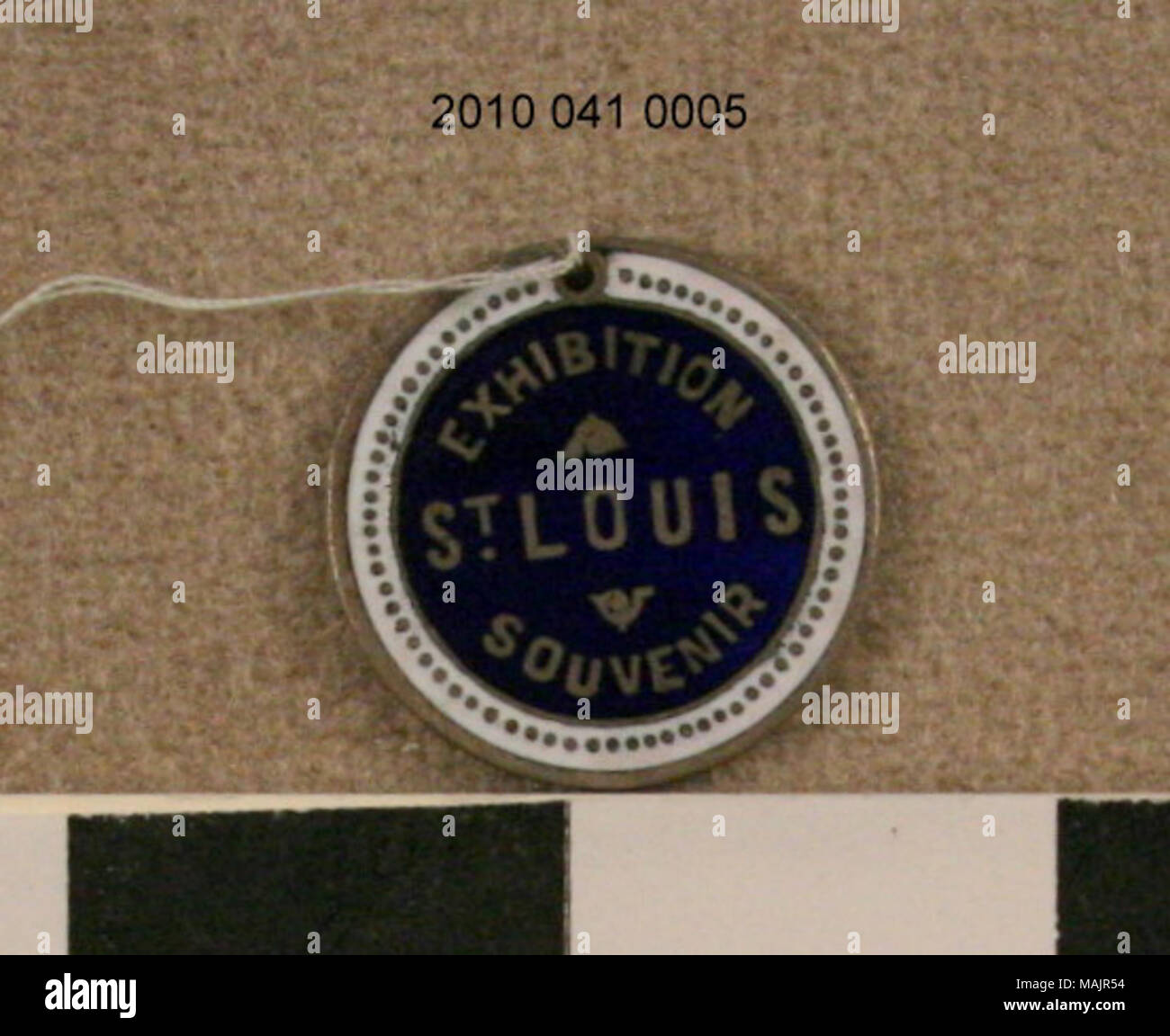 Souvenir de la poignée ronde 1904 World's Fair. L'avant est noir avec un anneau rouge autour de l'extérieur et avec '1904' en or. Dos est bleu avec bague blanche autour de l'extérieur et le lettrage en or. Titre : Exposition Universelle de 1904 Pendentif Souvenir . 1904. Banque D'Images