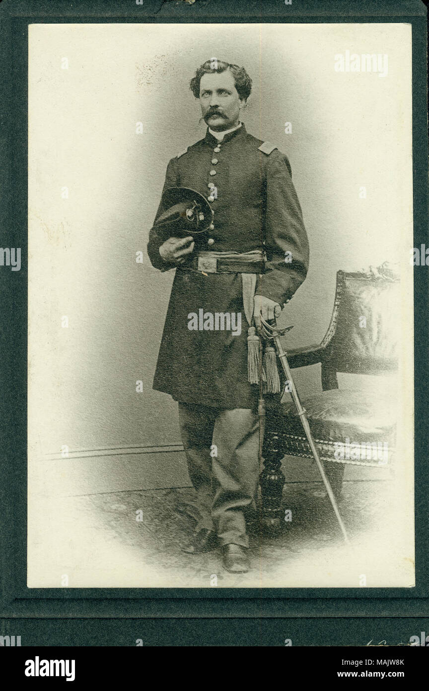Portrait en pied de Wesley C. Howe en uniforme, debout et tenant une épée dans sa main droite et un chapeau est sa main gauche. Il y a une chaise derrière lui à sa droite. Titre : Wesley C. Howe, 1er lieutenant, 2e de cavalerie du Massachusetts (Union européenne). . Entre 1861 et 1865. Banque D'Images