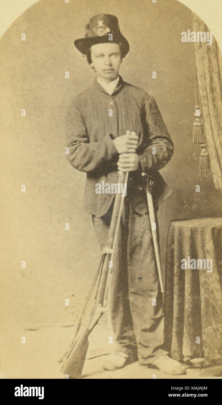 Portrait en pied d'un homme en uniforme avec fusil carabine-longueur et  style d'épée baïonnette. L'objet est de porter chapeau avec cor  (désignation d'infanterie) et de l'entreprise 'K' en 1914. 'John. J. Weber