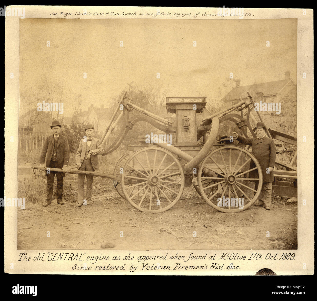 Photographie de horizontale trois hommes en chapeau melon avec un vieux cheval volunteer fire company panier. Note manuscrite sur la partie supérieure de la dit : "Joe Boyce, Charlie Fach et Tom Lynch sur l'un de leurs voyages de découverte, octobre 1889.' title : "l'ancien moteur "Central" comme elle est apparue lorsque trouvés à Mt. Olive, mauvais., octobre 1889. Depuis restauré par le vétéran de pompiers Hist. Soc." (L-R Joseph Boyce, Charlie Fach, Tom Lynch). . 1889. Banque D'Images
