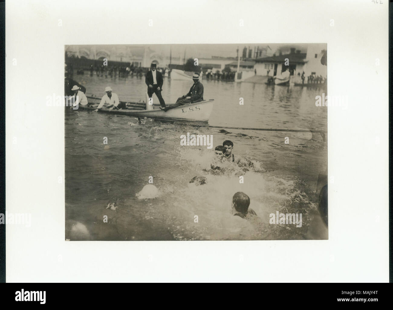 Trois ou quatre hommes dans l'eau lutte pour une balle qu'un bateau avec des fonctionnaires montres dans le coin supérieur gauche. Titre : Le New York et Chicago Water Polo equipes en action pendant les Jeux Olympiques de 1904 match de championnat. . 1904. Banque D'Images