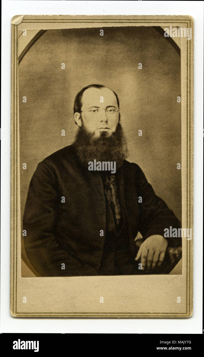 Portrait de mi-longueur d'un homme barbu portant un costume et lunettes avec son bras droit en appui sur une table. "Père Bannon forme après son retour de la guerre. Un de mes meilleurs amis" (écrit sur le verso). 'A.T. Pas de photographe URIE 1 Nord 4ème rue ST. LOUIS' ve (imprimé au verso). Jeune Père Bannon en 1861. Titre : Le Père John Bannon. . 1861. A.T. Urie, Saint Louis Banque D'Images