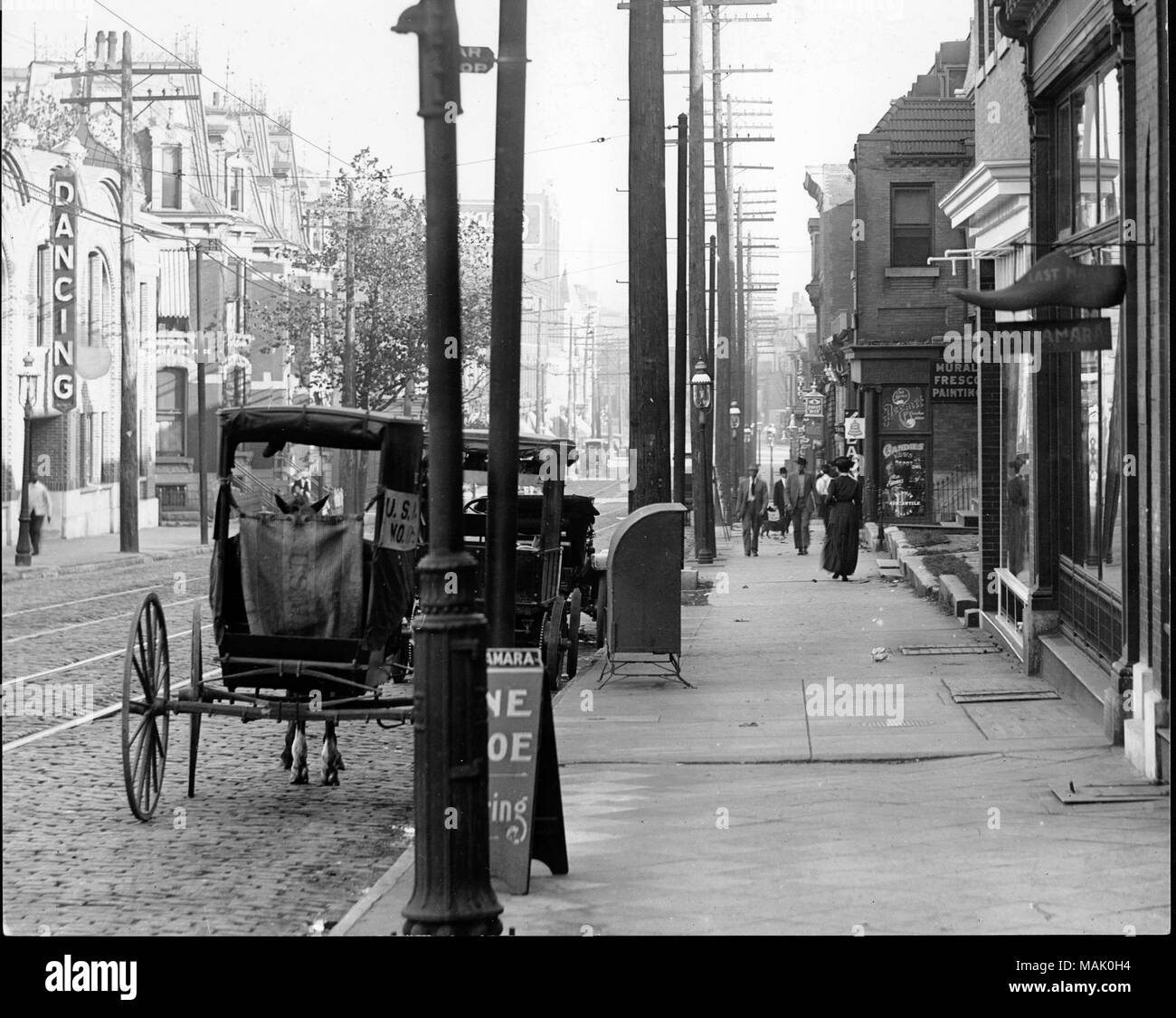 À l'horizontal, photographie en noir et blanc d'une vue sur la rue du 400e bloc de l'Avenue de la garnison. Mail calèches sont garé contre le trottoir sur la route pavée de briques. Les piétons marcher le long de la boutique bordée de trottoirs. Titre : 400 mètres au sud de l'Avenue de la garnison. . Vers 1900. Swekosky, William G., 1895-1964 Banque D'Images