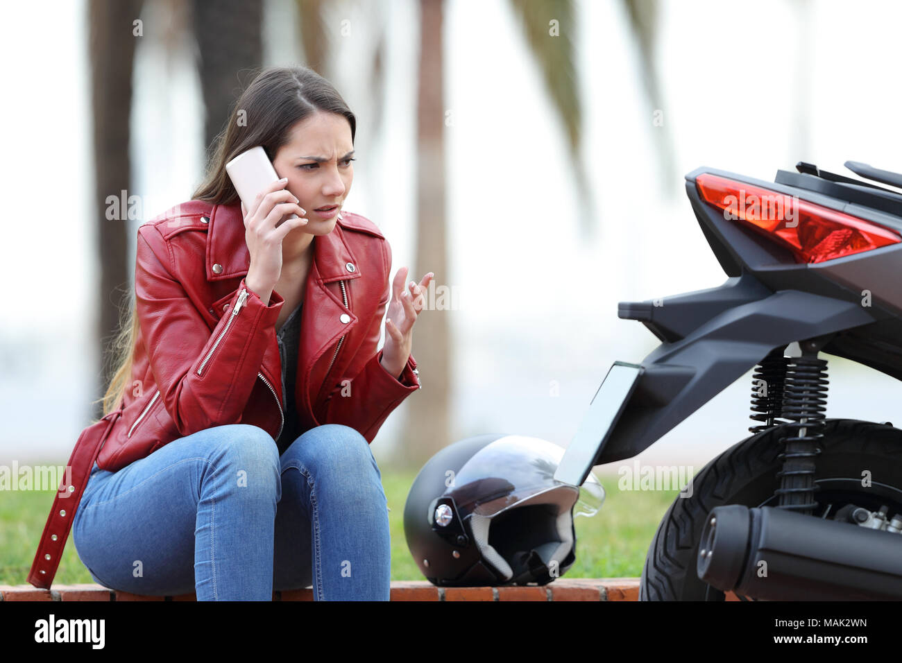 Portrait d'un motard en colère appelant à côté d'une assurance moto à  l'extérieur dans la rue Photo Stock - Alamy
