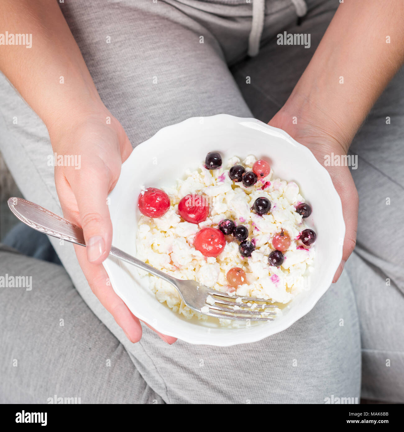 La fille est maintenant une assiette de fromage cottage Banque D'Images