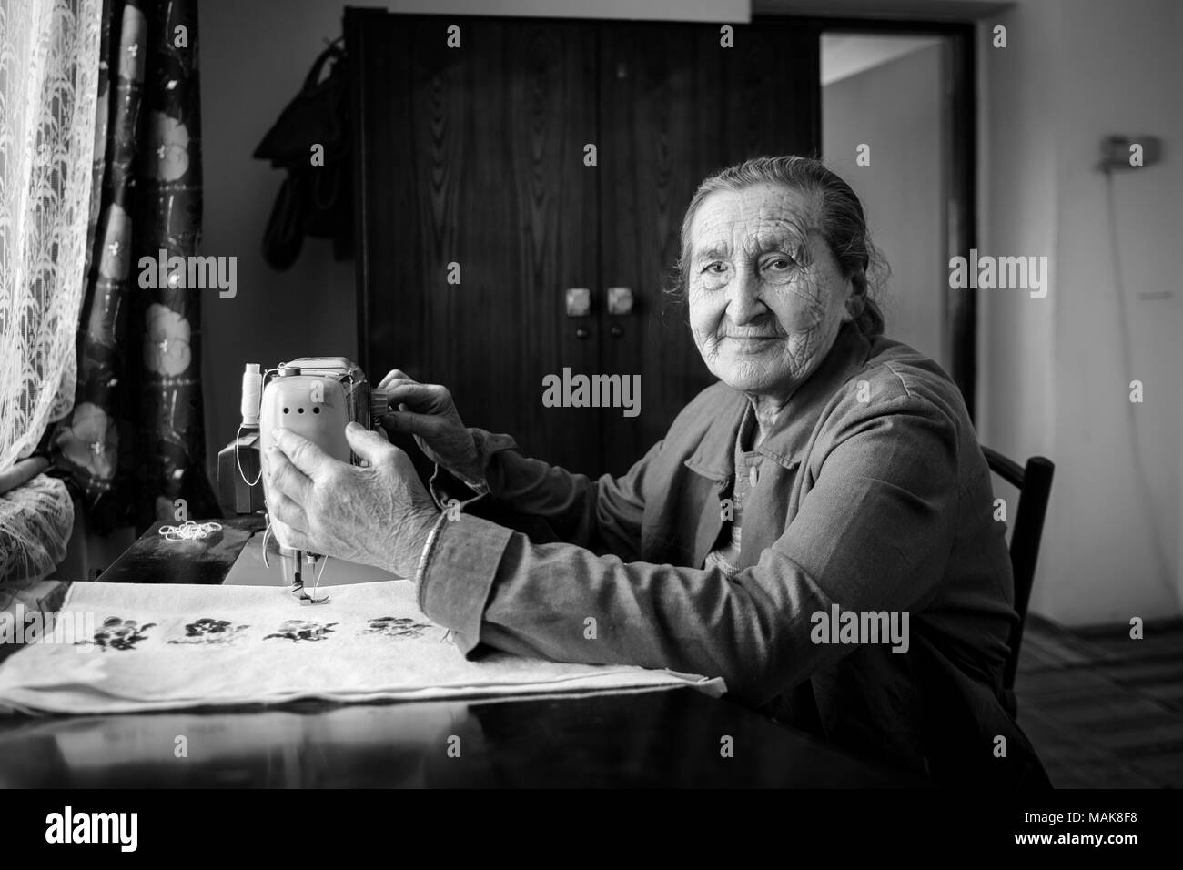 Plus de 80 ans mignon senior woman using vintage machine a coudre. Image en noir et blanc de l adorable vieille dame vetements couture dans sa vieille maison familiale Photo Stock Alamy