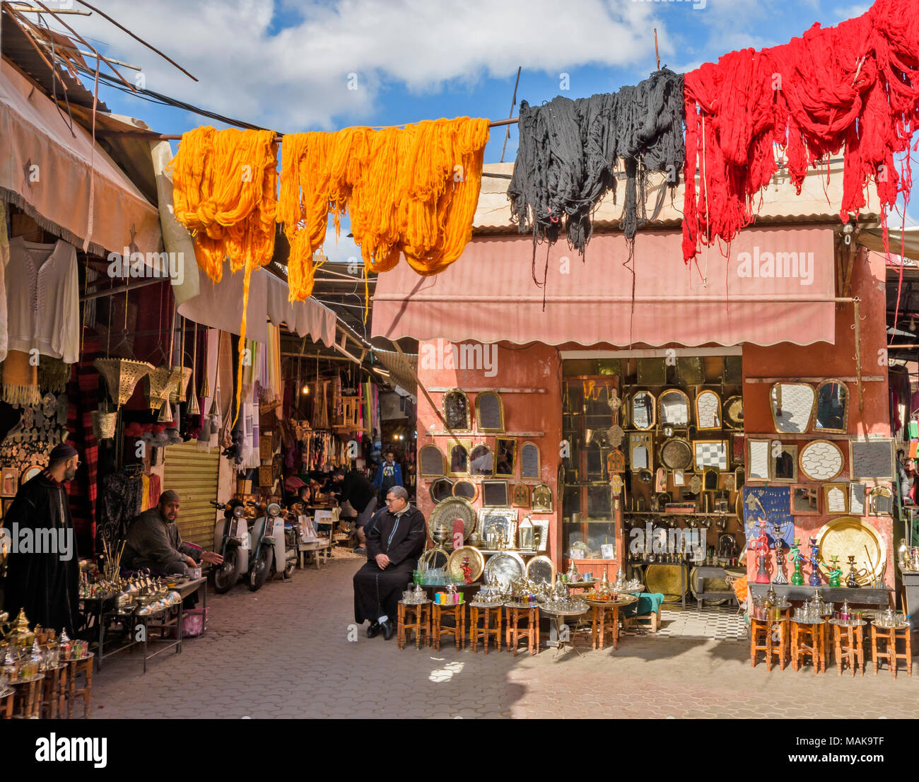 Place JEMAA EL FNA MARRAKECH MAROC Souk Médina boutiques avec laine teints multicolores suspendus poteaux pour sécher au soleil Banque D'Images