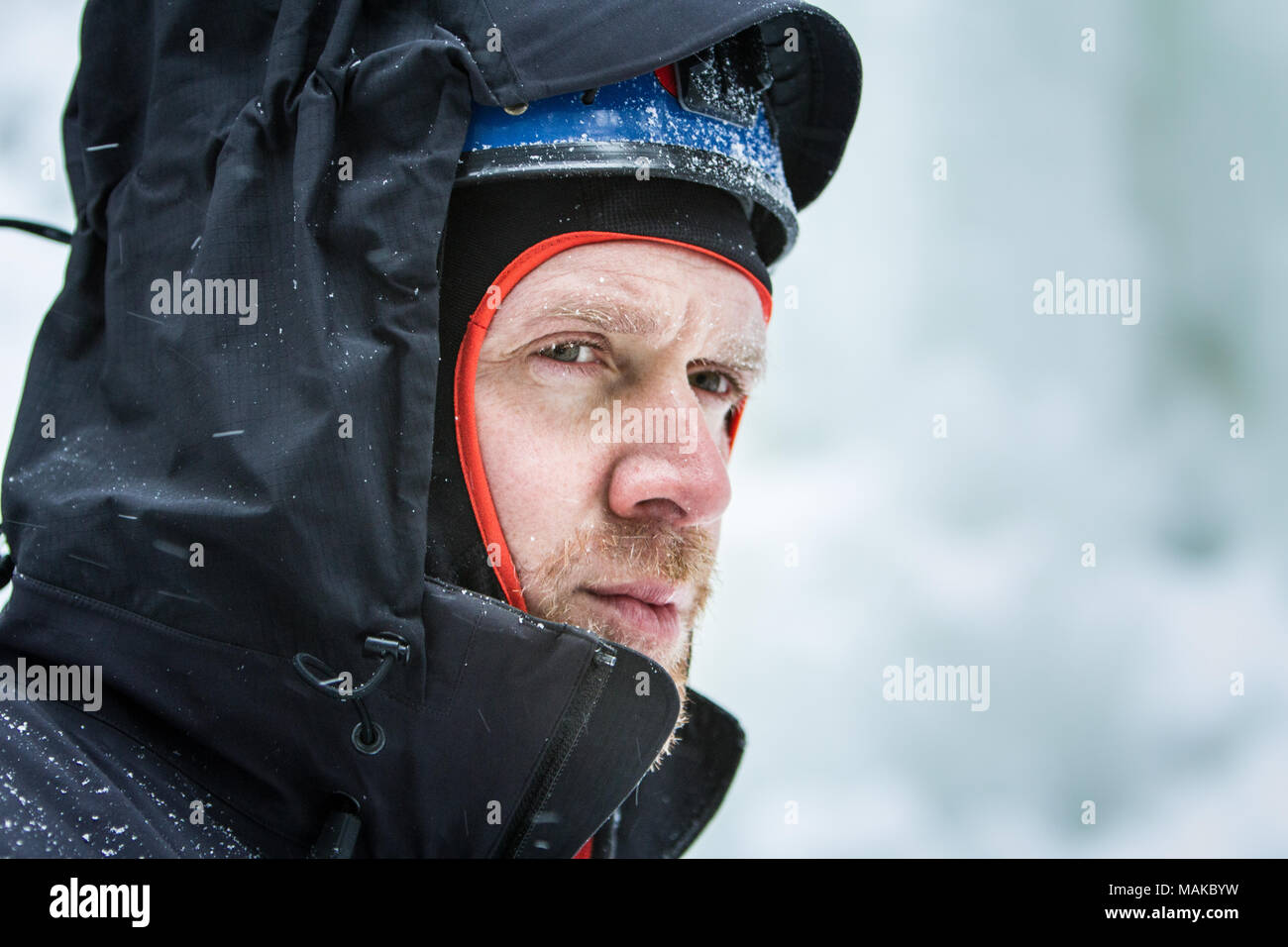 Un grimpeur sur glace fixe en avant, contre le vent et les températures froides. Banque D'Images