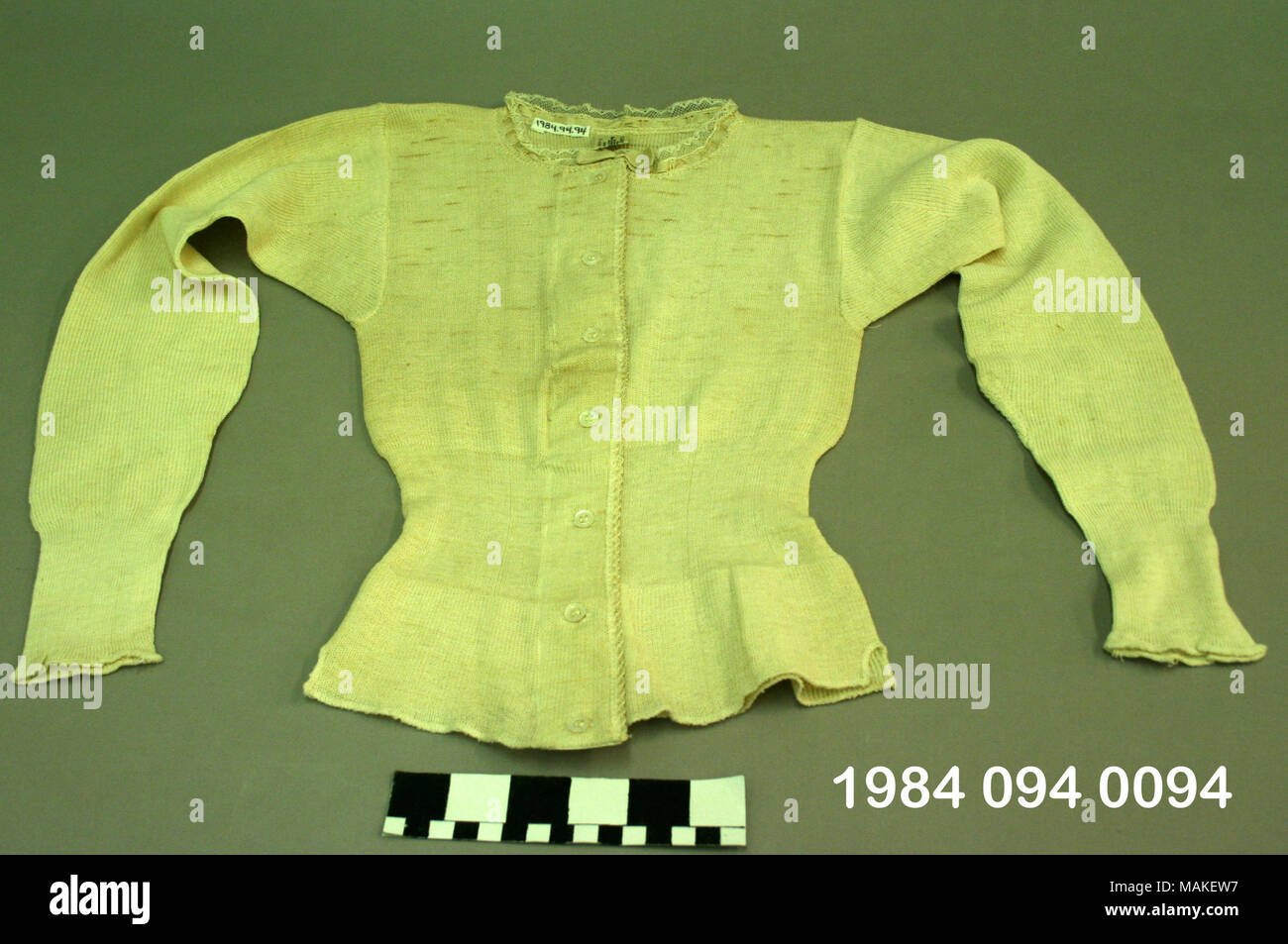 Women's off-white knit underbodice avec manches longues, encolure circulaire et ligne de taille définie. Les boutons du vêtement à l'avant du cou jusqu'à l'ourlet. Porté par l'Ida Rose ou Emilie Rose Uhri, soeurs qui ont vécu à Saint Louis. Titre : la femme Off-White Knit Underbodice . vers 1900. Approvisionnement direct Co. Banque D'Images