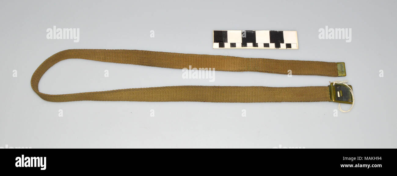 Olive ceinture tissée avec languette de métal à une extrémité et dent métal  boucle cinch sur l'autre. Porté en tant que partie d'un uniforme militaire  pendant la Seconde Guerre mondiale I. Titre :