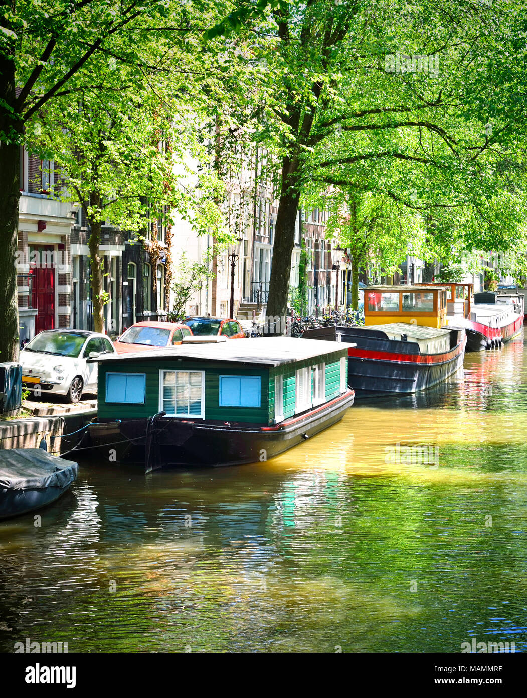 Canal d'Amsterdam avec dutch maisons et de la rivière Amstel. Scène de printemps ou d'été et la ville d'Amsterdam. Maisons de ville historiques. Banque D'Images