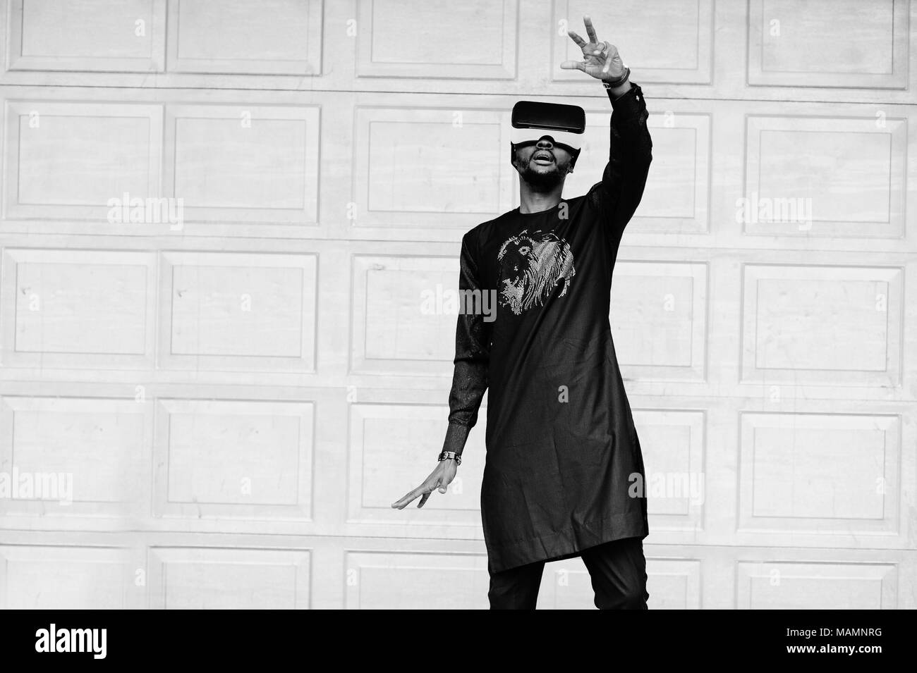 Riche homme africain dans l'élégant quartier de vêtements traditionnels en rv lunettes. Avenir de l'Afrique concept. Banque D'Images